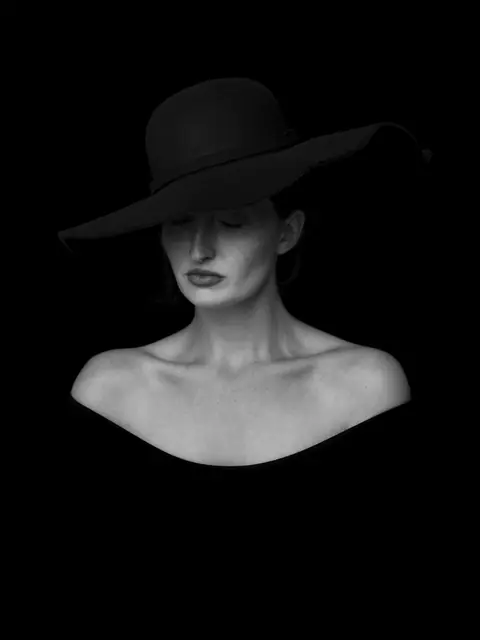 Retrato editorial de mulher com chapéu em fundo preto