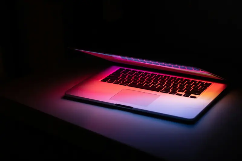 Notebook entreaberto brilhando no escuro